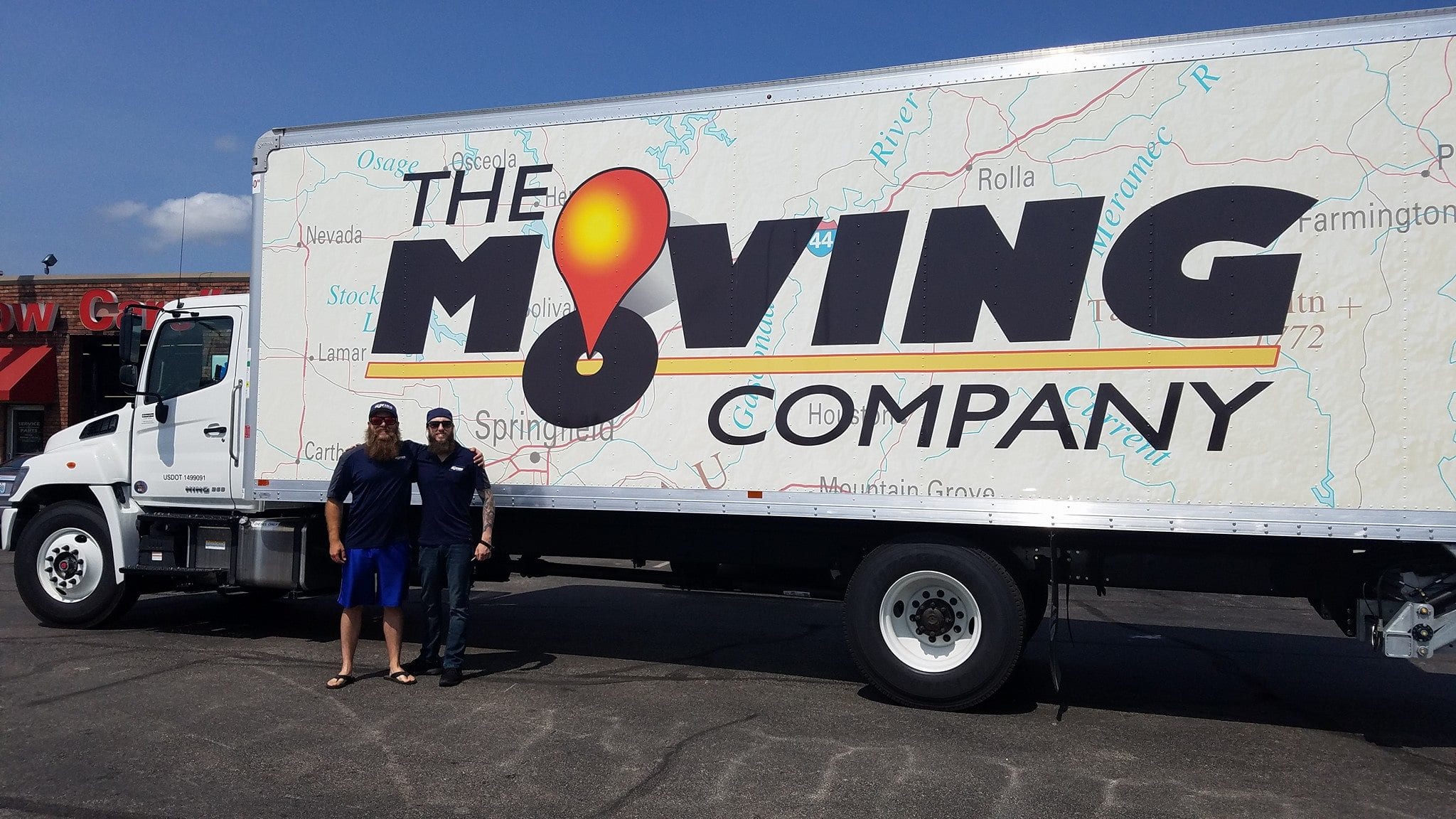 Two Guys Next to a Large Moving Truck