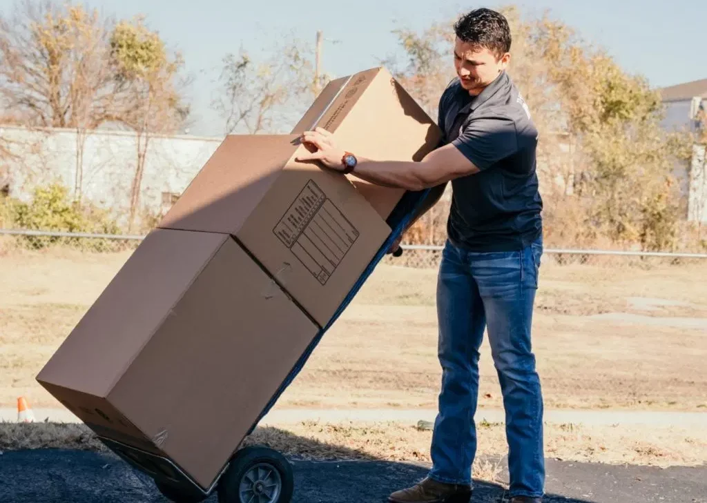 the moving company team member using dolly for cardboard boxes