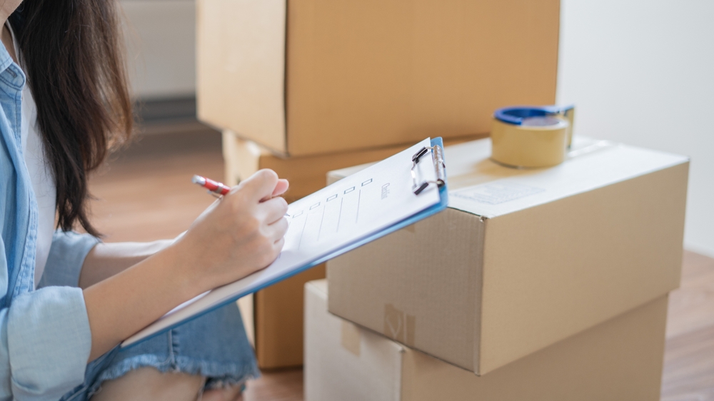 Woman checks her packing list while preparing for a move