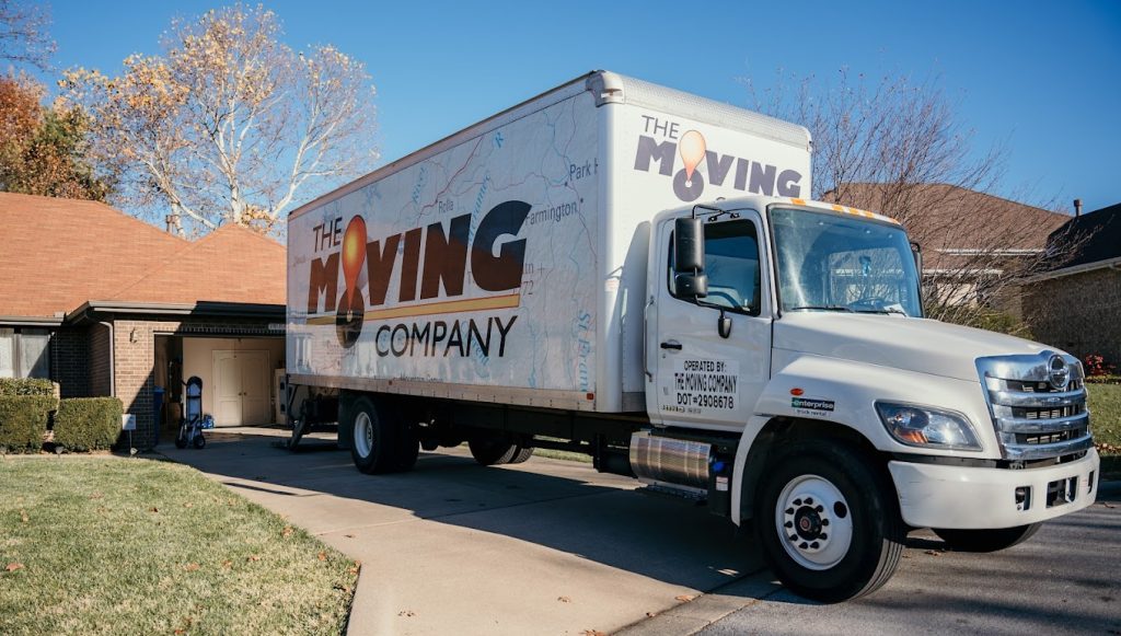 The Moving Company truck parked in front of a house